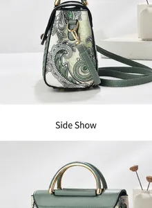 Detalle del bolso verde oscuro con estampado paisley y asa de metal dorado elegante