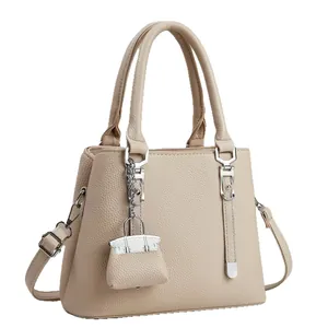 Elegante beige handtas van generfd leer voor dames met schouderriem en zilveren details