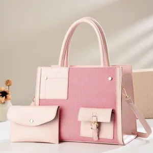 Detalle de bolso tote rosa en lona con mini monedero a juego y hebillas doradas de lujo