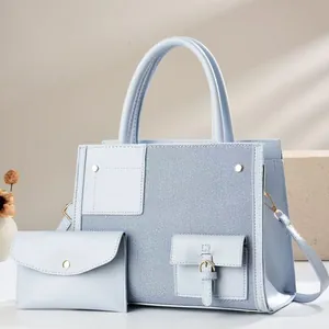 Detalle del bolso bandolera de retazos de cuero y mezclilla azul claro con herrajes metálicos