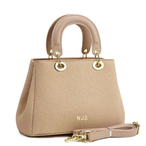 Détail de la texture tissée et du logo NJS doré sur le sac fourre-tout beige