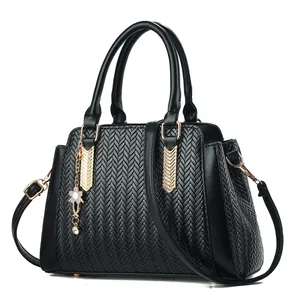 Elegante zwarte geweven handtas voor dames met gouden details en bloemenhanger