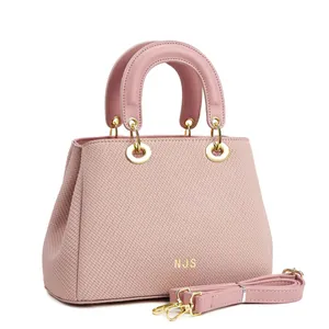 Vue détaillée du sac cabas rose tissé avec logo NJS doré et bandoulière réglable amovible