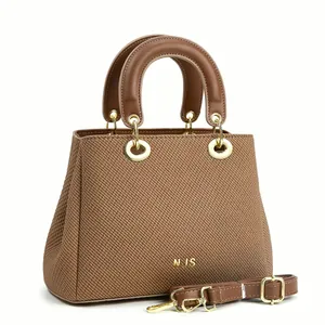 Détail de la texture tissée marron et du logo NJS en métal doré sur le sac à main