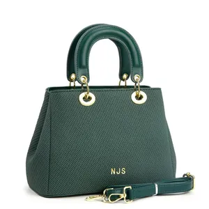Gros plan du sac cabas vert foncé avec texture tissée, logo NJS doré et finitions métal