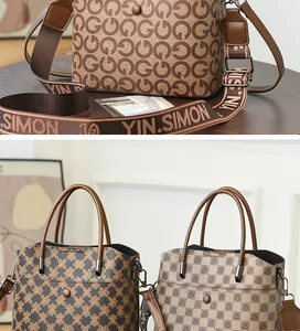 Dettaglio della borsa a secchiello stampata con ampia tracolla in tessuto e finitura monogram