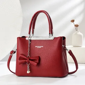 Borsa a mano rossa in pelle a grana con fiocco e decorazione catena di perle