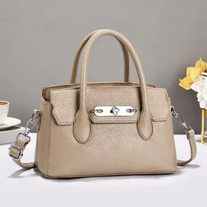 Detail van kaki crossbodytas van generfd leer met zilveren hardware en handvatten