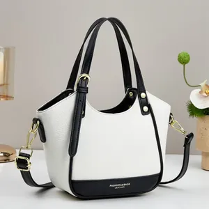 Close-up of contrast leather handbag with gold hardware and logo on pebble texture