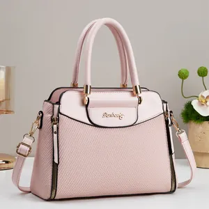 Elegant pale pink woven leather handbag for women featuring top handles and long shoulder strap