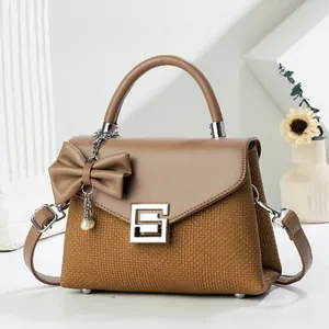 Detail of vintage patchwork handbag with silver square buckle and pearl bow charm