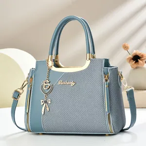 Elegante Morandi-blaue Handtasche mit goldenen Beschlägen auf einem minimalistischen Podest