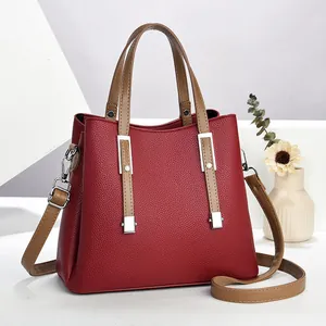 Dettaglio borsa rossa in pelle martellata con dettagli argento e manici a contrasto