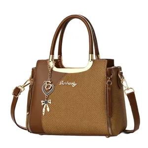 Elegante braune Patchwork-Handtasche mit goldenen Beschlägen und Metallanhänger