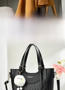 Détail du sac à main noir en cuir avec texture à chevrons et boucles dorées