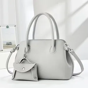 Close-up of light gray pebbled leather Boston bag set with a mini coin purse charm