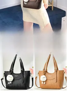 Détail de sacs cabas en similicuir tressé avec breloque en peluche en couleurs