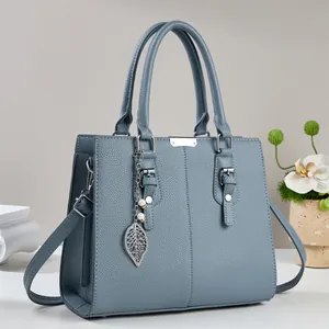 Sac à main bleu en cuir grainé avec pendentif perle et bandoulière réglable