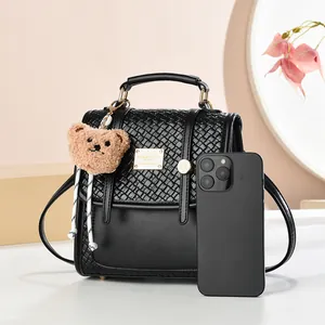 Zaino alla moda in pelle nera con trama intrecciata e ciondolo a forma di orso