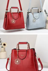 Close-up detail of leather texture and metallic rose pendant on a stylish handbag