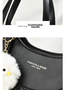 Détail du sac à main en cuir grainé noir avec chaîne dorée et breloque peluche