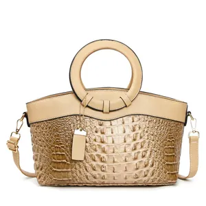 Elegant beige faux crocodile skin handbag with round handle and adjustable strap