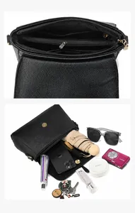 Detail view of the black textured leather handbag featuring five interior compartments and magnetic clasp