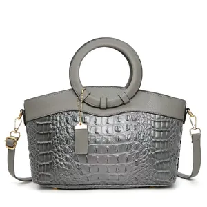 Elegant grey faux crocodile leather handbag with circular handle and crossbody strap