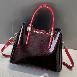 Close-up of deep red snake-pattern patent leather handbag with glossy texture