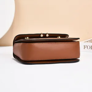 Elegant caramel leather crossbody bag with pearl accents and gold hardware details