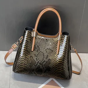 Macro view of glossy faux snake skin texture and gold hardware on retro crossbody handbag