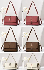 Detail view of brown and pink crossbody bags with litchi grain leather and buckles