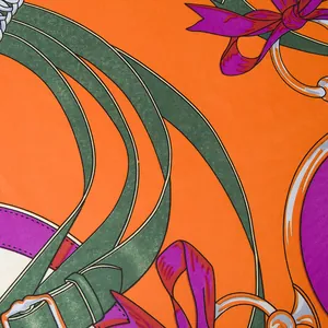 Macro shot of silk scarf showing orange equestrian belt print and twill weave texture