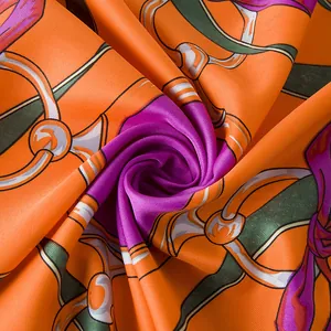Close-up of silk twill scarf showing glossy texture and vintage horsebit chain patterns