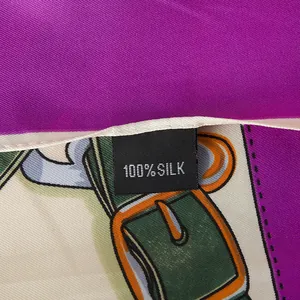 Macro shot of 100% silk label on scarf with chain and green leather belt print detail