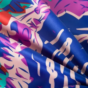 Close-up of vibrant satin silk scarf with tropical leaves and tiger print texture