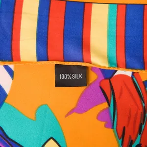 Macro shot of colorful striped silk scarf featuring 100% silk label and fine texture