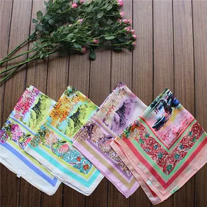 Detail of four colorful silk-like square scarves with oil painting scenery and floral prints
