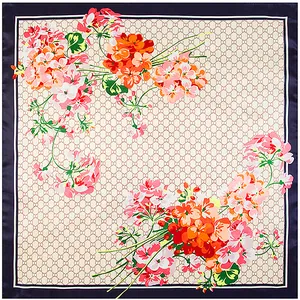 Detail eines Seidenschals mit ineinandergreifendem G-Muster und bunten Pelargonien