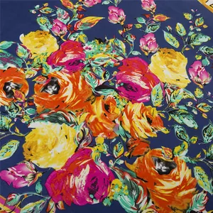 Detail of vibrant floral print on dark blue fabric showing texture and artistic patterns