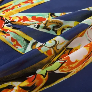 Close-up of silk square scarf featuring baroque floral prints and deep blue satin fabric