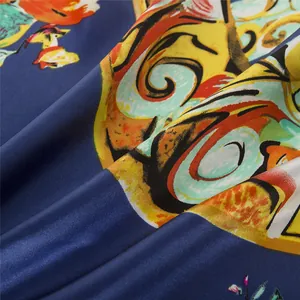 Close-up of silk scarf fabric showing vibrant artistic prints and smooth satin texture