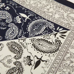 Macro detail of navy paisley pattern on satin square scarf with ornate geometric borders