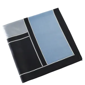 Detail of geometric patchwork silk scarf with blue and black color blocks and white dots