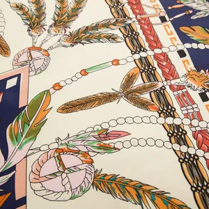 Macro detail of silk scarf showing intricate feather, bead prints and bohemian patterns