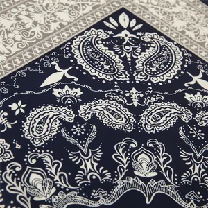 Macro view of navy blue satin silk paisley pattern and detailed floral print on the scarf
