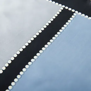 Detailed macro view of geometric patterned silk scarf with polka dots and fine twill texture