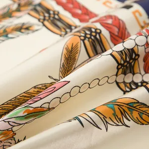 Macro view of silk scarf fabric showing elegant feather patterns and satin texture