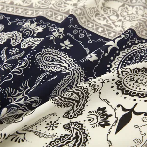 Detail of silk satin scarf featuring ethnic paisley pattern with soft fabric draping