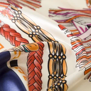 Macro shot of silk square scarf featuring detailed tassel rope patterns and satin texture